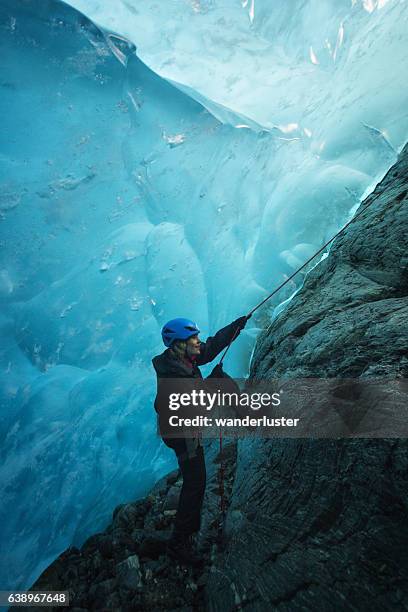 betreten einer welt aus blauem eis - eisklettern stock-fotos und bilder