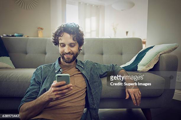man checks smartphone - sofa stock pictures, royalty-free photos & images