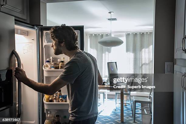 man checks refrigerator - inside fridge stockfoto's en -beelden