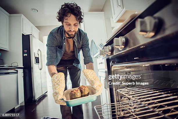 man prepares meal in kitchen - man cooking photos et images de collection