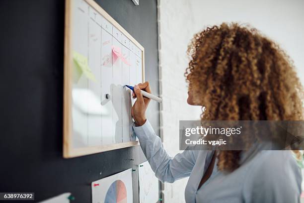 latina businesswoman writing schedule. - agenda stockfoto's en -beelden