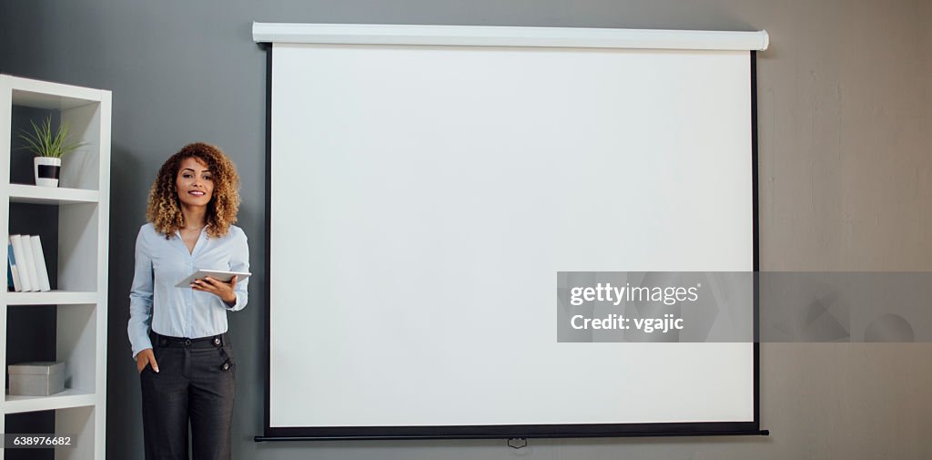 Latina mujer de negocios tener presentación en su oficina.