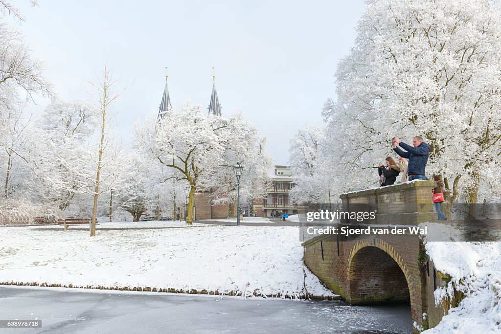 People taking pictures of the snowy wintry landscape in Kampen