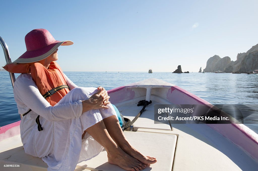 Woman relaxes in boat on tranquil sea
