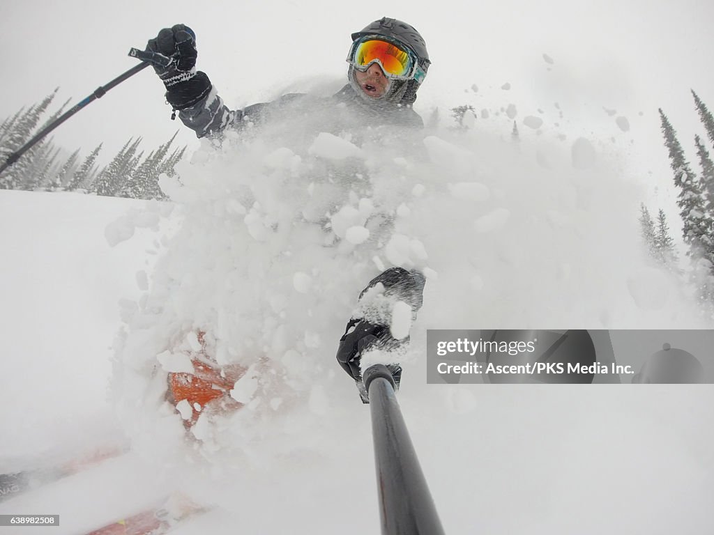 POV of skier descending deep powder snow, forest