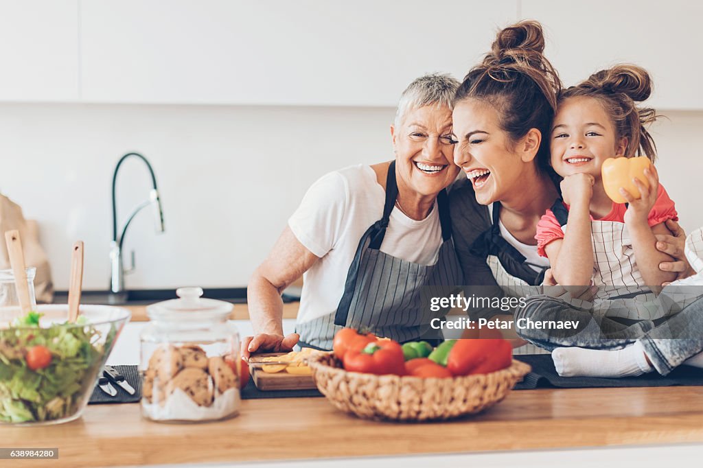 Three generations women laughing in the kitchen