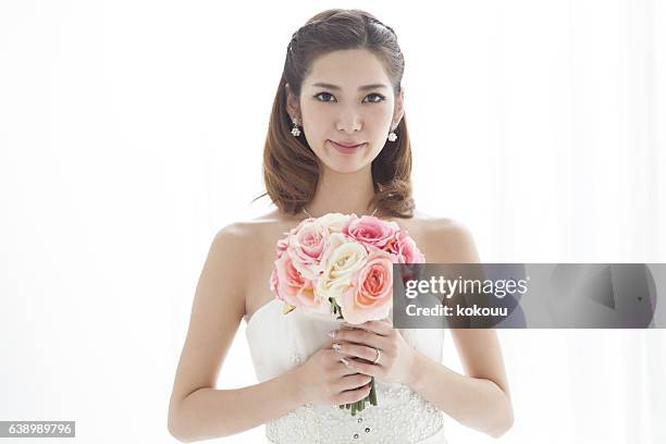 close-up of a bride with a red bouquet. - wedding hair stock pictures, royalty-free photos & images