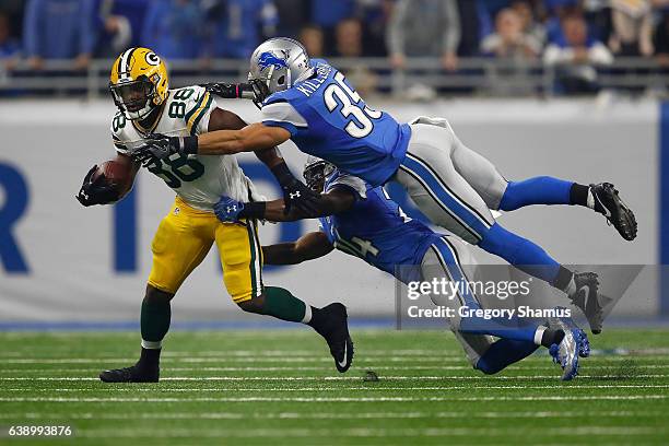 Ty Montgomery of the Green Bay Packers tires to escape the tackle of Miles Killebrew of the Detroit Lions and Nevin Lawson at Ford Field on January...