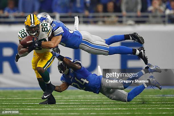 Ty Montgomery of the Green Bay Packers tires to escape the tackle of Miles Killebrew of the Detroit Lions and Nevin Lawson at Ford Field on January...