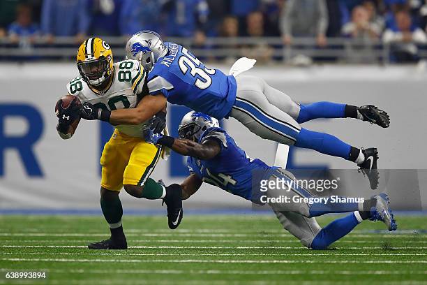 Ty Montgomery of the Green Bay Packers tires to escape the tackle of Miles Killebrew of the Detroit Lions and Nevin Lawson at Ford Field on January...
