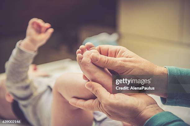 mutter kümmert sich um ihr kleines baby - aus nächster nähe - foot massage stock-fotos und bilder