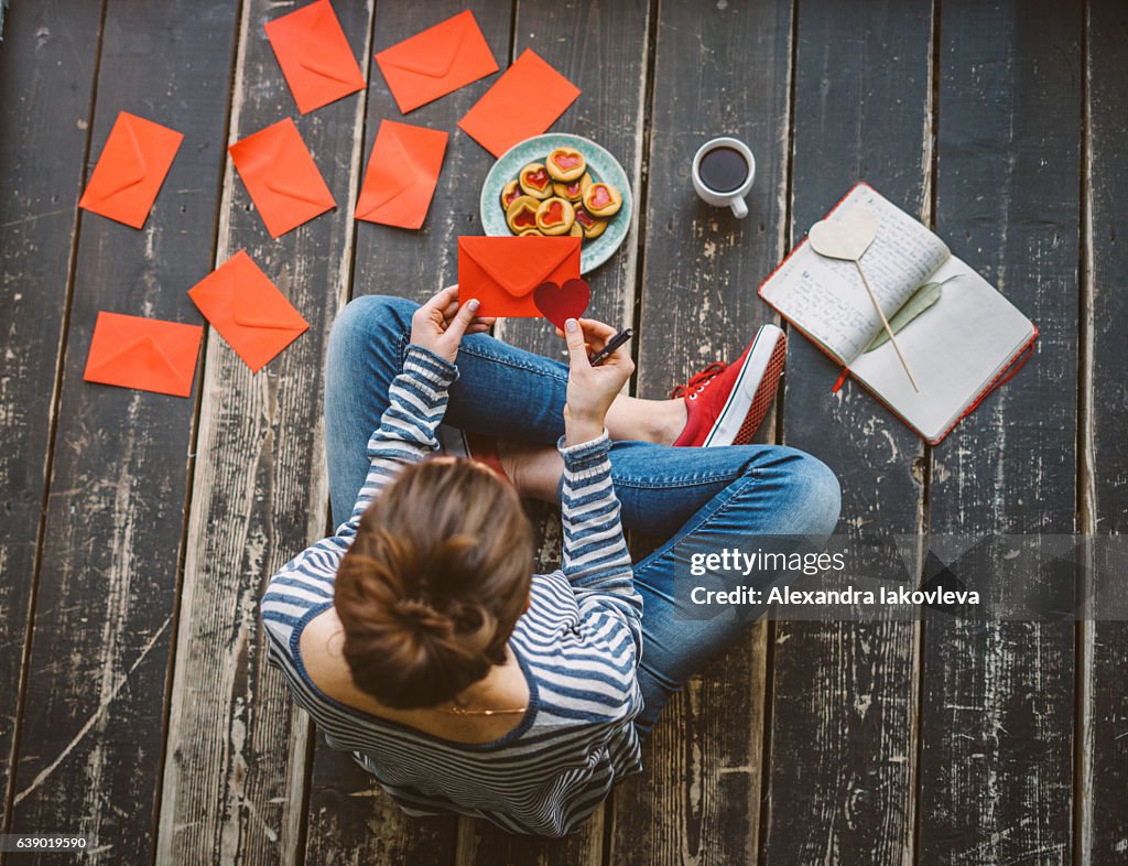 Young woman writing a valentine card - top view