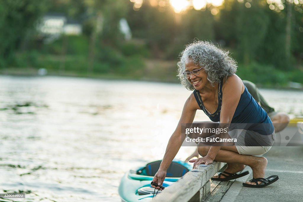 Older mature couple putting kayak in the water together