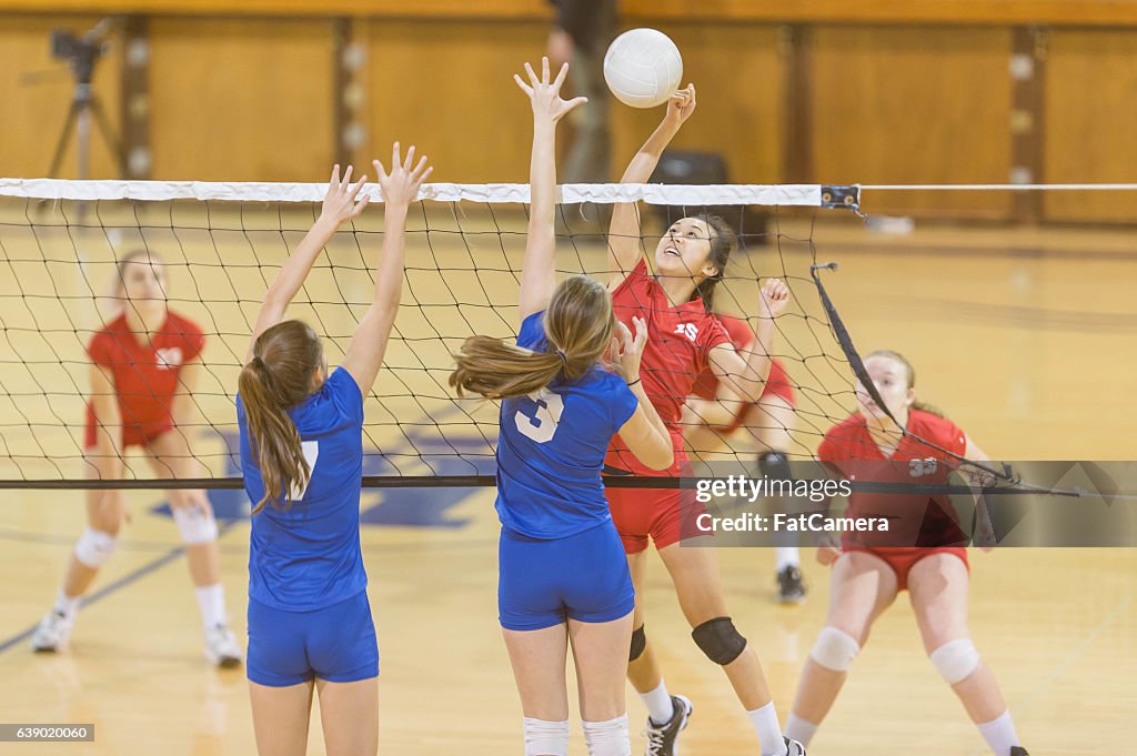 High school female volleyball player spiking the ball