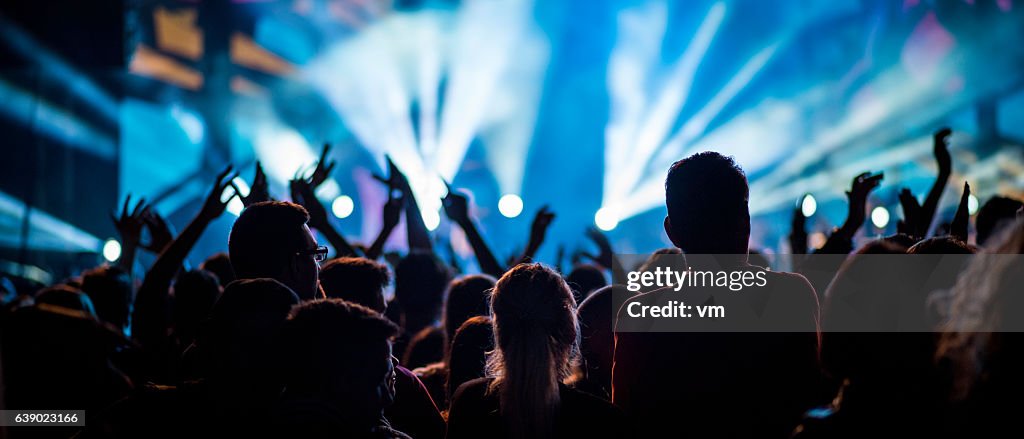 People at a concert with raised hands