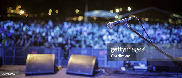 bühnenmikrofon und konzertpublikum - festival bühne stock-fotos und bilder