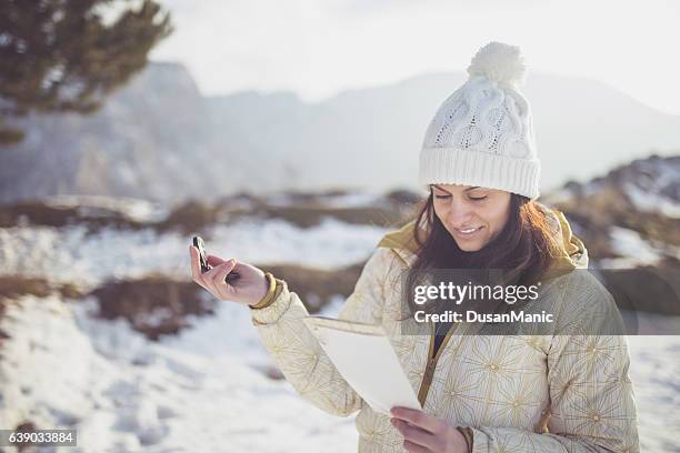 donna escursionista che legge la mappa in montagna durante un viaggio escursionistico. - woman looking through ice foto e immagini stock