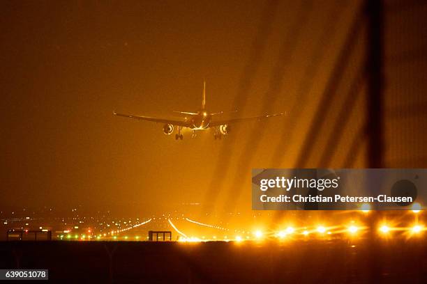 airplane landing at night on runway - landing gear stock-fotos und bilder