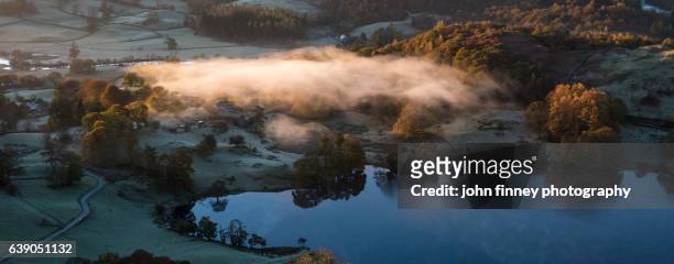 loughrigg tarn with golden mist at sunrise. lake district national park. uk. - lingmoor fell stock pictures, royalty-free photos & images