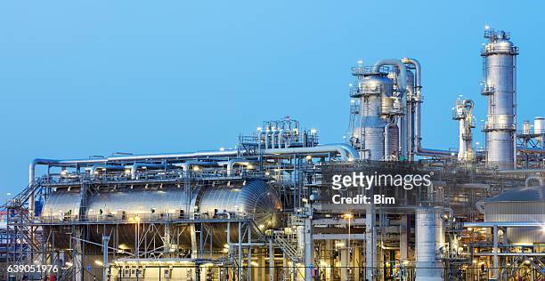 oil refinery iluminated at dusk - oil refinery stock pictures, royalty-free photos & images