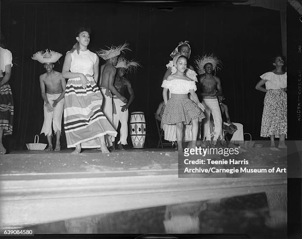Young women and men from Victor Hereford dancers, and six-year-old Dianne Littlejohn in front, wearing Caribbean style costumes, dancing on stage for...