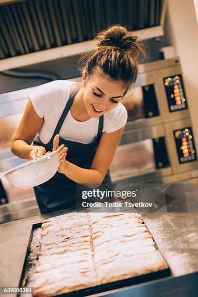 female baker pouring powdered sugar on pastry - sieve stock pictures, royalty-free photos & images
