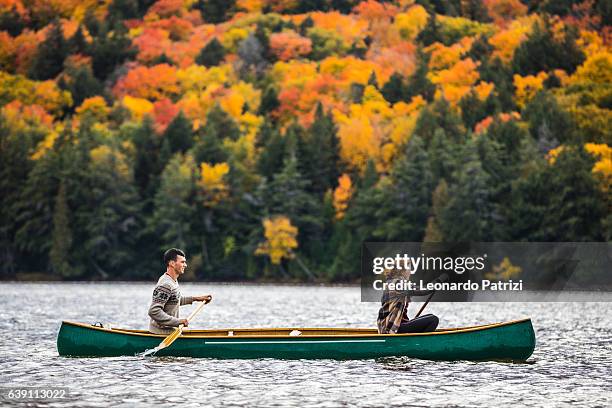couple enjoying a ride on a typical canoe in canada - canoeing stock pictures, royalty-free photos & images