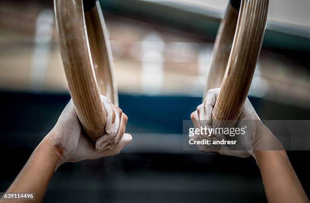 athlete using gymnastics rings - gymnastiek stockfoto's en -beelden