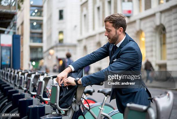business man renting a bike in london - london bikes stock pictures, royalty-free photos & images