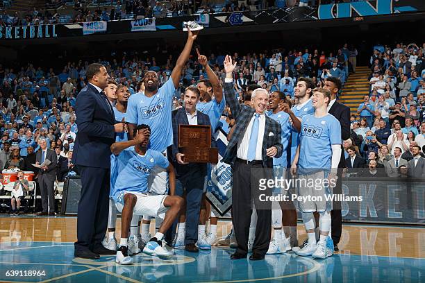 Head coach Roy Williams of the North Carolina Tar Heels is honored for his win number 800. Brandon Robinson, left with hand on face, reacts after...