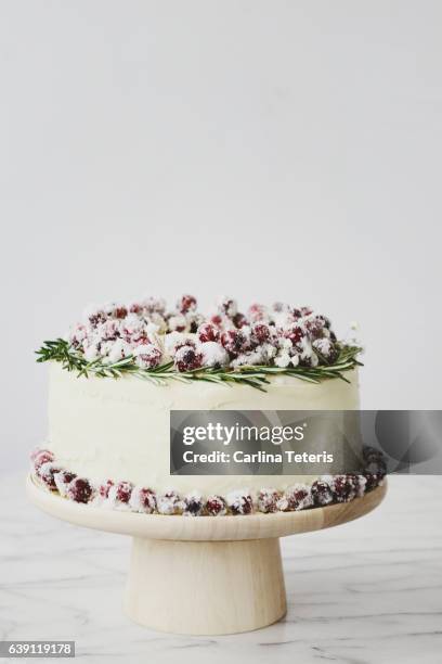 elegant, minimalist christmas tier cake decorated with a rosemary and cranberry wreath - yule marble stock pictures, royalty-free photos & images