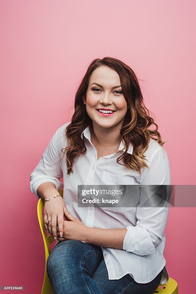 Casual cute young woman on pink