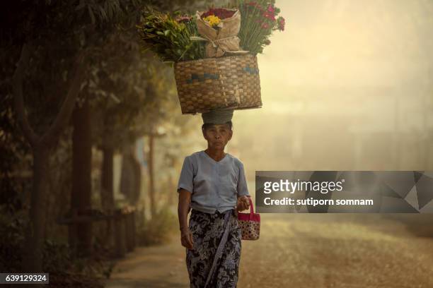 women took flowers  put on the cart path to market - cambodjaanse cultuur stockfoto's en -beelden