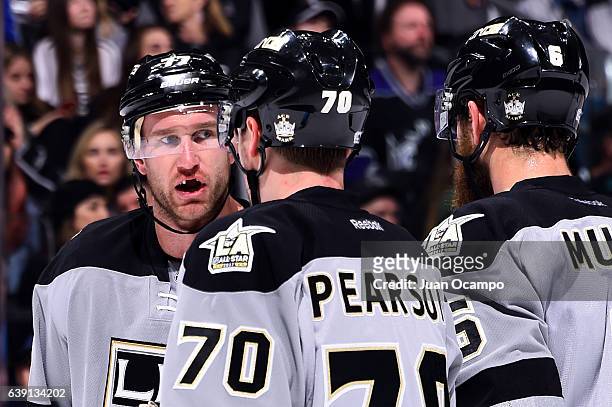 Jeff Carter, Tanner Pearson, and Jake Muzzin of the Los Angeles Kings chat before taking a face-off during the game against the Winnipeg Jets on...