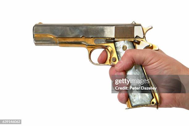 criminal hand firing handgun - gold revolver stock pictures, royalty-free photos & images