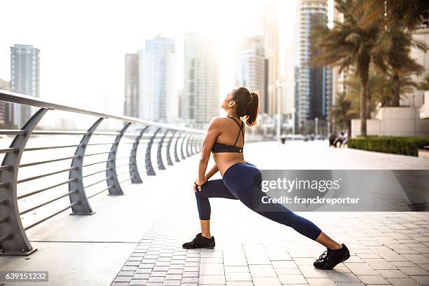 fitness woman doing stretching in dubai marina - calf human leg stock pictures, royalty-free photos & images