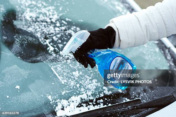 ice scraping en defrost spray on car windscreen - windscreen stock pictures, royalty-free photos & images