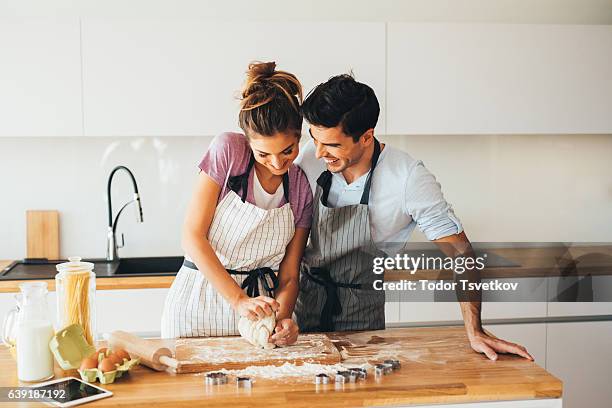 couple making cookies - man baking cookies stock pictures, royalty-free photos & images