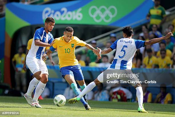 Day 12 Neymar of Brazil is challenged by Kevin Lopez of Honduras and Allans Vargas of Honduras in action during the Brazil Vs Honduras Men's...