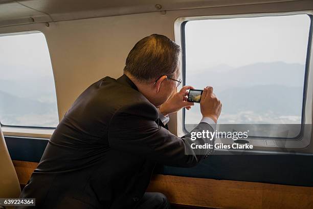 Onboard one of the Korean Presidential Helicopters. The UN Secretary General Ban Ki-moon takes photo of the Korean landscape while on his way from...