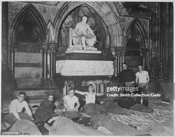 Young male American soldiers dressed in pajamas and wrapped in wool sleeping bags go to rest for the night inside the Royal Courts of Justice in...