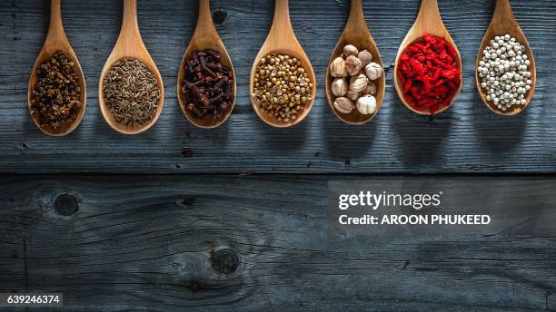 spices on spoons in wooden background - condiment stock pictures, royalty-free photos & images