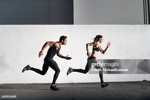 hispanic man and women running together - coaching couple stock pictures, royalty-free photos & images