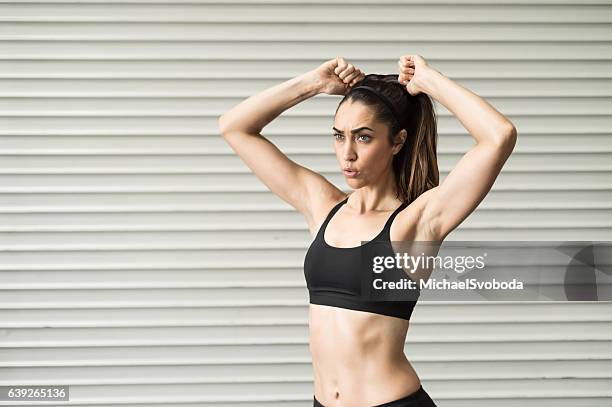 hispanic women pulling back her hair - woman pulling hair back stock pictures, royalty-free photos & images