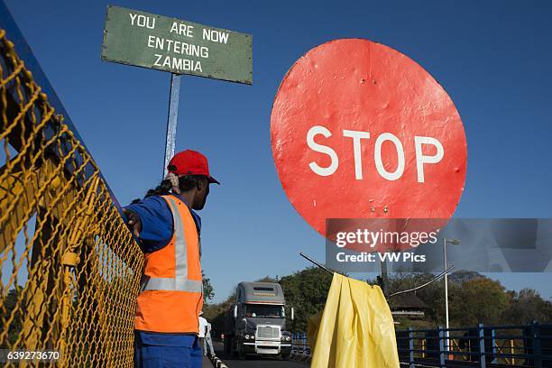 Woman controls the traffic between Zambia and Zimbabwe. A STOP sign indicates that we are entering Zambia. Today one of the Victoria Falls Bridge's...