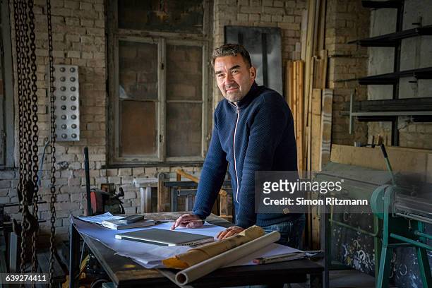 portrait of confident craftsman in workshop - man and machine fotografías e imágenes de stock