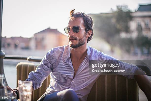 handsome man in cafe - sunlit cafe male stock pictures, royalty-free photos & images