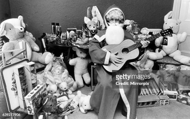 Rod Johnson, a guitar playing Father Christmas, surrounded by toys, ready for a Round Table tombola, Redcar, 11th December 1980.