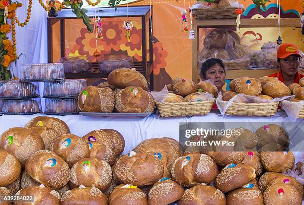 Women selling traditional Mexican Bread called Bread of the Dead in Oaxaca market. This bread eaten during Day of the Dead festivities in Mexico.