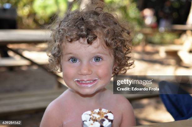 young girl eating ice cream cone. - girl eating messy ice cream cone stock-fotos und bilder